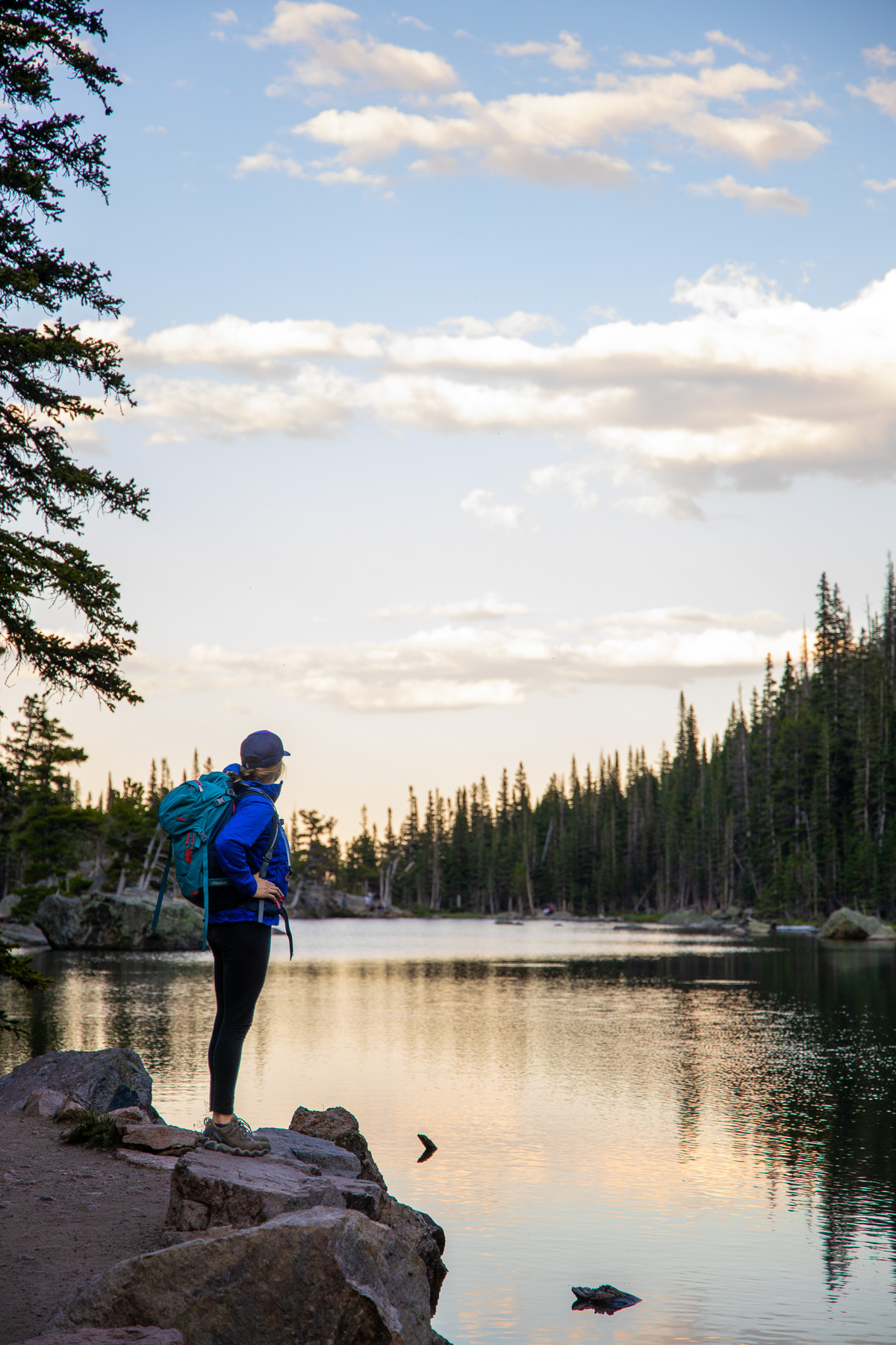 Kristen Bor standing at edge of a mountain lake at sunset